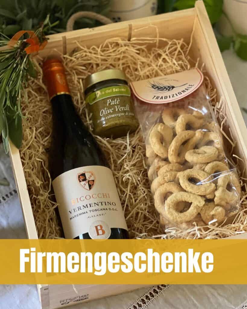Holzgeschenkbox mit einer Flasche Vermentino‑Wein, Olivenpaté und traditionellen italienischen Gebäckringen, dekoriert mit Kräutern.