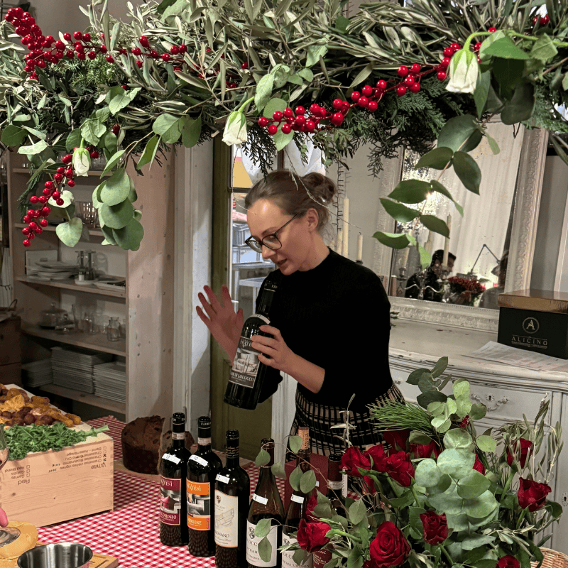 Ein Sommelier schenkt an der Weihnachtsdegustation vom 28.11.2026 Wein ein, umgeben von festlicher Dekoration und Weingläsern.